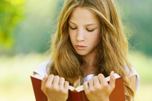 young girl reading outside - AKB purchase stock photo